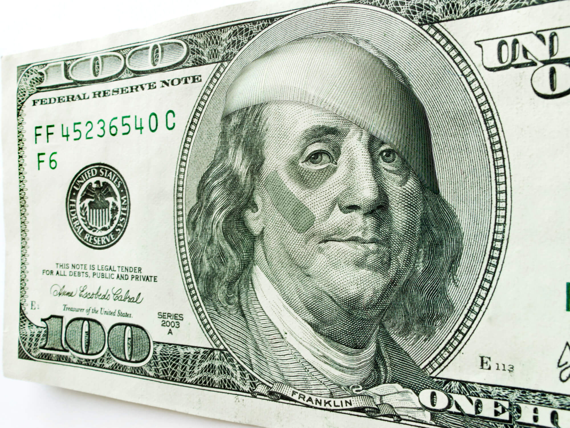 Ben Franklin with black eye and bandages in one-hundred-dollar bill illustrating rising inflation